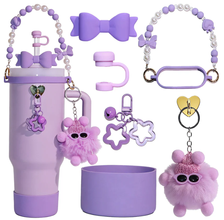Pastel purple tumbler accessory gift set featuring a silicone cup boot, straw topper, pearl carry strap, handle grip, fluffy pom-pom keychain, and decorative charms.