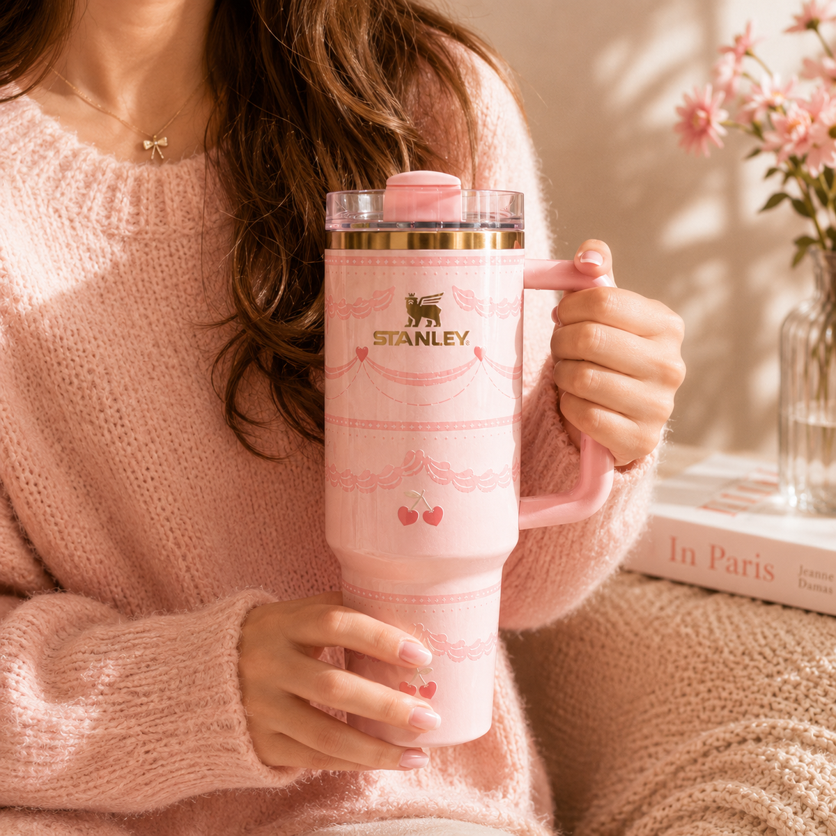 Person holding a pink Stanley tumbler with floral design
