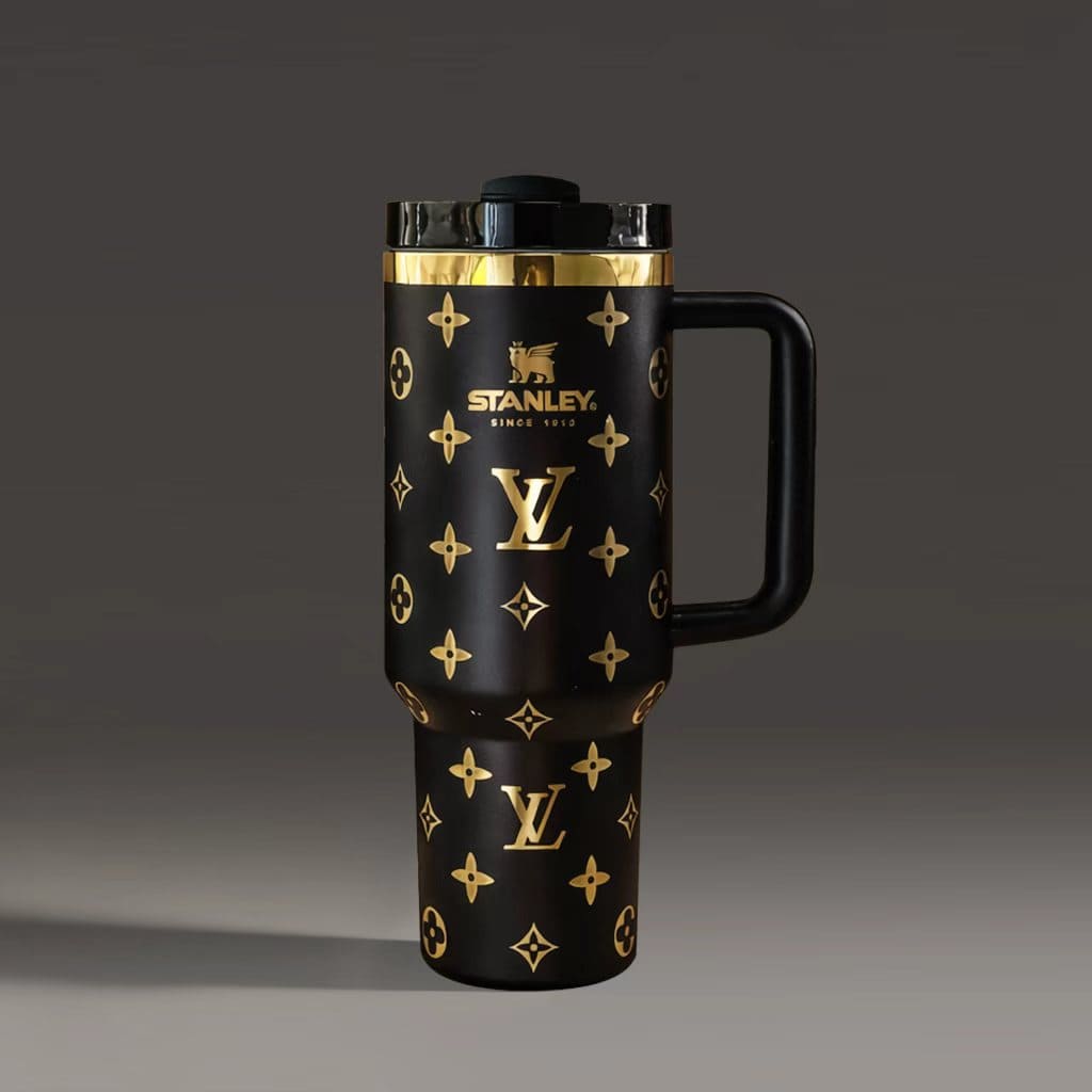 Black travel mug with gold patterns and Stanley logo on a dark background