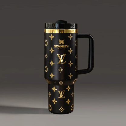 Black travel mug with gold patterns and Stanley logo on a dark background