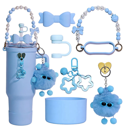 Pastel blue tumbler accessory gift set featuring a silicone cup boot, straw topper, pearl carry strap, handle grip, fluffy pom-pom keychain, and decorative charms.