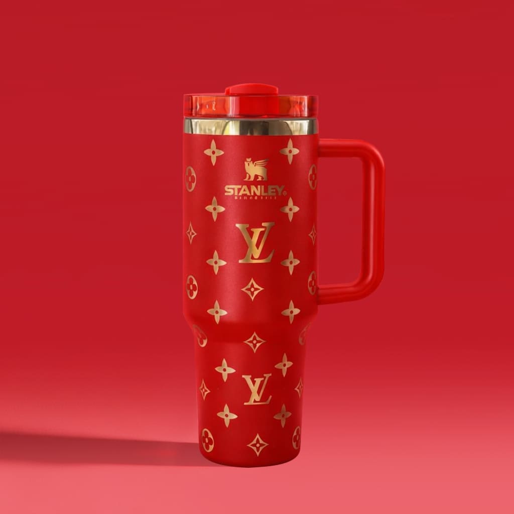 Red travel mug with gold patterns and Stanley logo on a red background