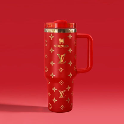Red travel mug with gold patterns and Stanley logo on a red background
