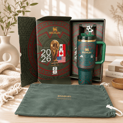 Stanley mug with packaging and pouch on a wooden surface