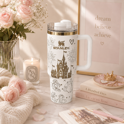 Stanley travel mug with princess design on a decorative table with flowers and books.