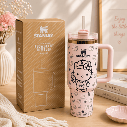 Stanley tumbler with Hello Kitty design next to its packaging on a wooden surface.