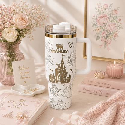 Stanley tumbler with princess-themed design on a decorative table with flowers and books.