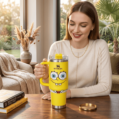 Woman holding a yellow Stanley tumbler with a cartoon character design in a cozy living room.