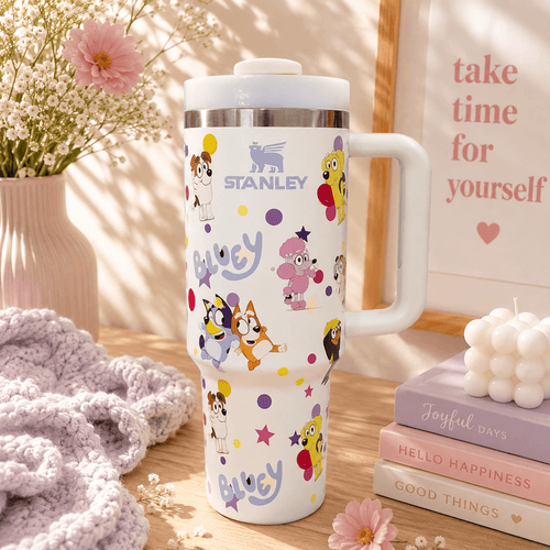White Stanley 40oz insulated tumbler featuring colorful Bluey-inspired character artwork with ergonomic handle and reusable lid.