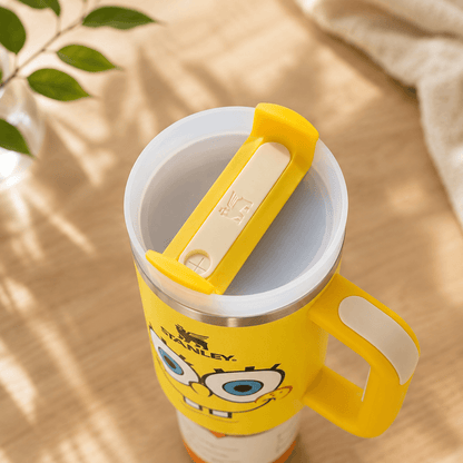 Yellow mug with a cartoon character design on a wooden surface