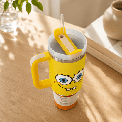 Yellow tumbler with a cartoon character on a wooden surface