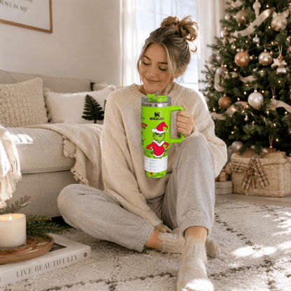 Woman sitting on the floor holding a green mug with a Christmas tree in the background