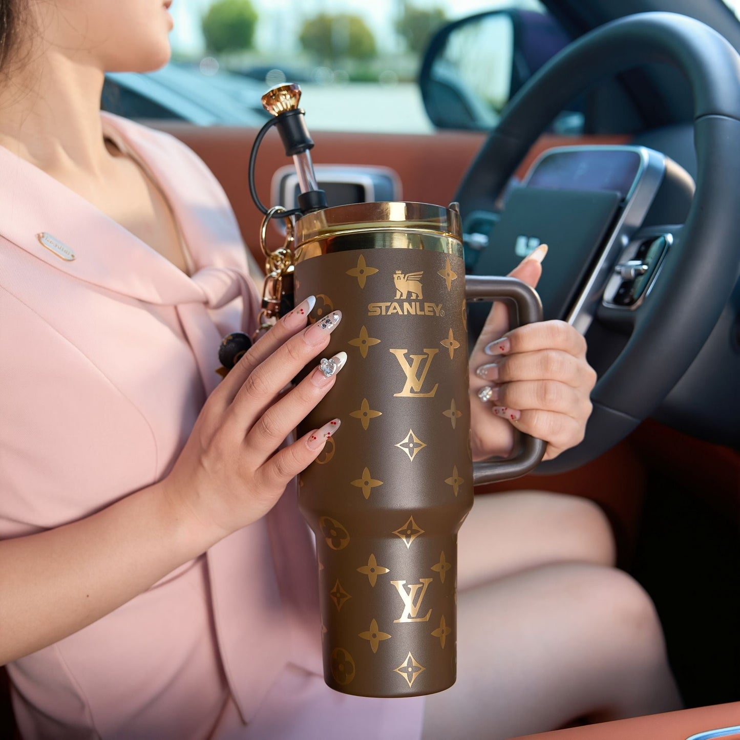 Person holding a branded tumbler in a car